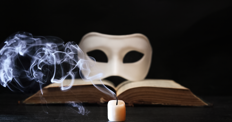 Maske mit Kerze und Buch