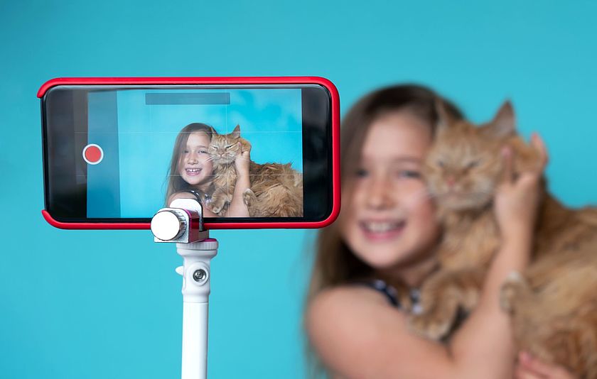 Mädchen posiert mit einer Katze für ein Smartphone-Video