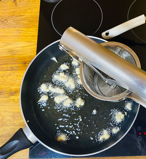 Zwiebeln in einer Pfanne für die Moodlesuppe