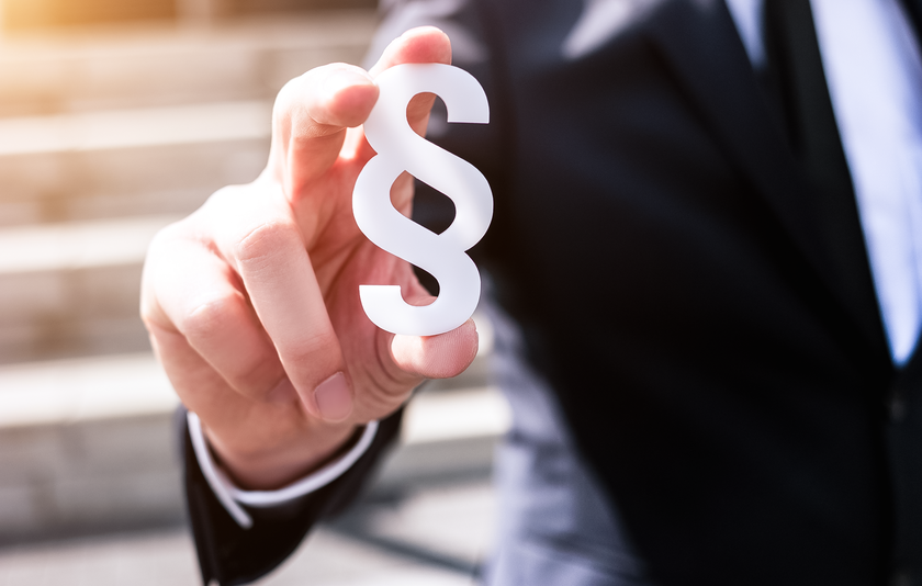 Mann mit Paragraphenzeichen in der Hand Mann mit Paragraphenzeichen in der Hand