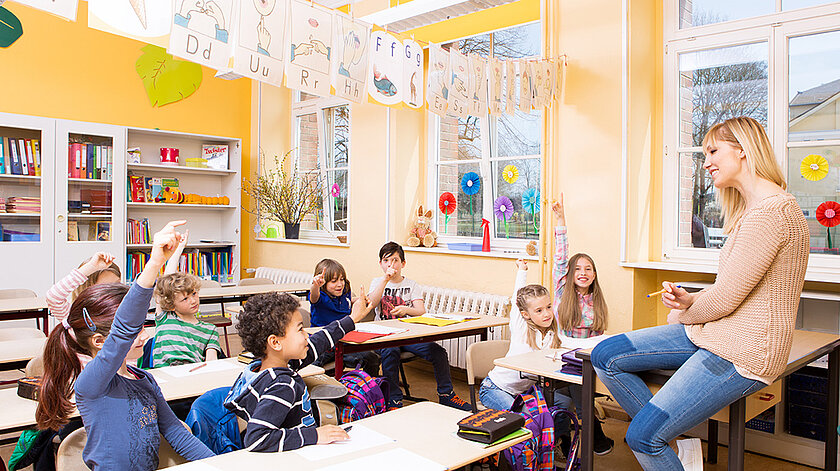 Grundschullehrerin im Unterricht mit Schülerinnen und Schülern.
