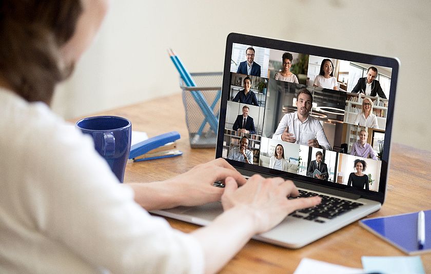 Frau am Laptop mit Videokonferenz auf dem Bildschirm