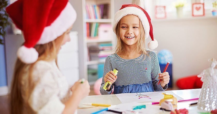 Zwei Mädchen mit Nikolausmützen beim Basteln
