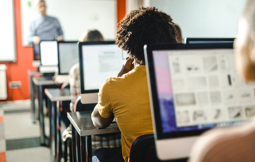Computerraum Schüler vor Bildschirmen in einem Klassenraum