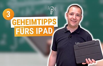 Man sieht einen braunhaarigen Mann mit einem iPad in der Hand, der lacht.