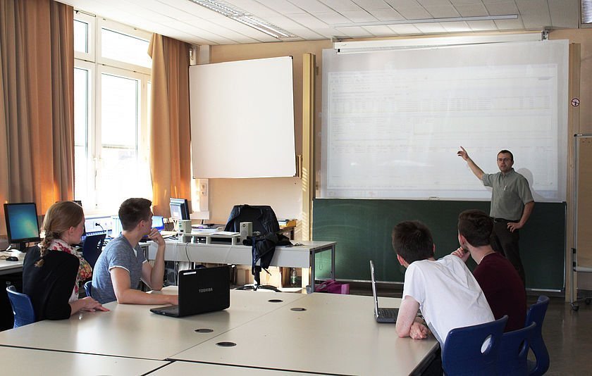Lehrer unterrichtet seine Klasse mithilfe eines Whiteboards