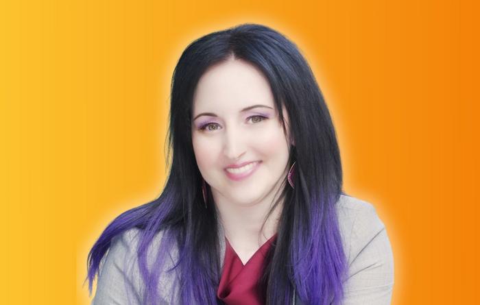 Frau mit schwarzen langen Haaren mit lila Spitzen in hellgrauem Blazer