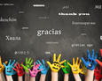 Bemalte Hände vor einer Tafel mit dem Wort Danke in vielen Sprachen