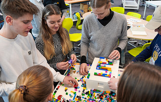 Lernende auf der Didacta 2023 an einem Legotisch