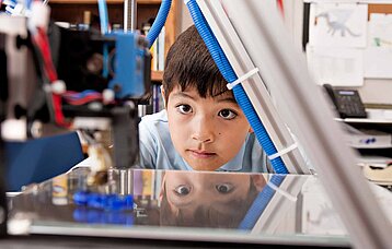 Junge vor 3D Drucker