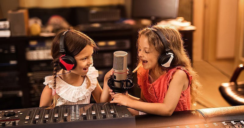 Zwei kleine Mädchen in einem Tonstudio mit Kopfhörern