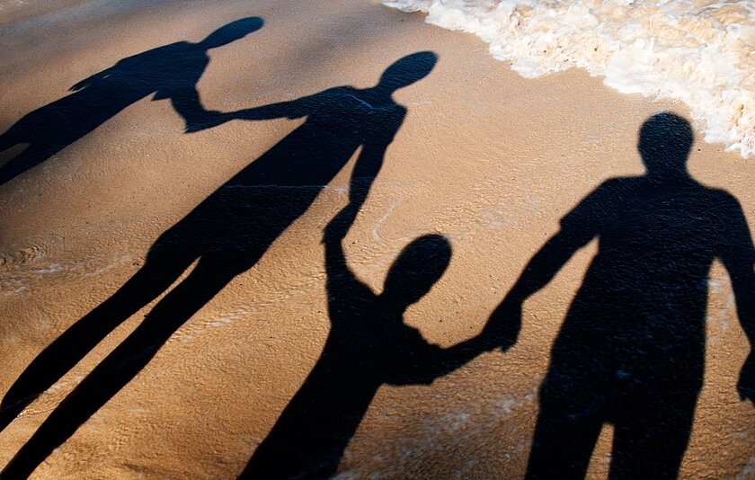 Idee 6: Schattenspiele fotografieren Das Foto zeigt die Schatten einer vierköpfigen Familie am Strand.