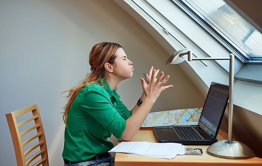 Wütende Frau bei der Arbeit am Laptop