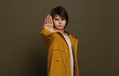 Junge macht Stop-Geste mit rechter Hand