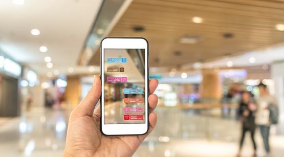 Hand hält ein Smartphone, mit Bewertungs-Icons auf dem Display
