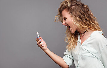 Frau schreit Smartphone an