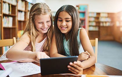 Zwei Grundschülerinnen mit einem Tablet