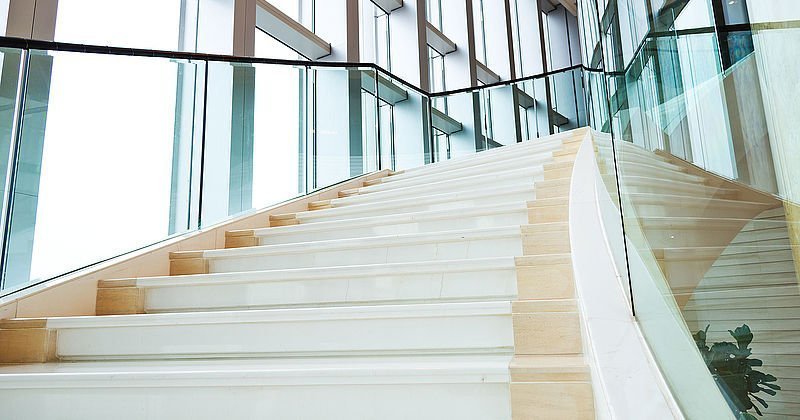 Weiße Treppe als Architektur-Element in licht-durchflutetem Aufgang.