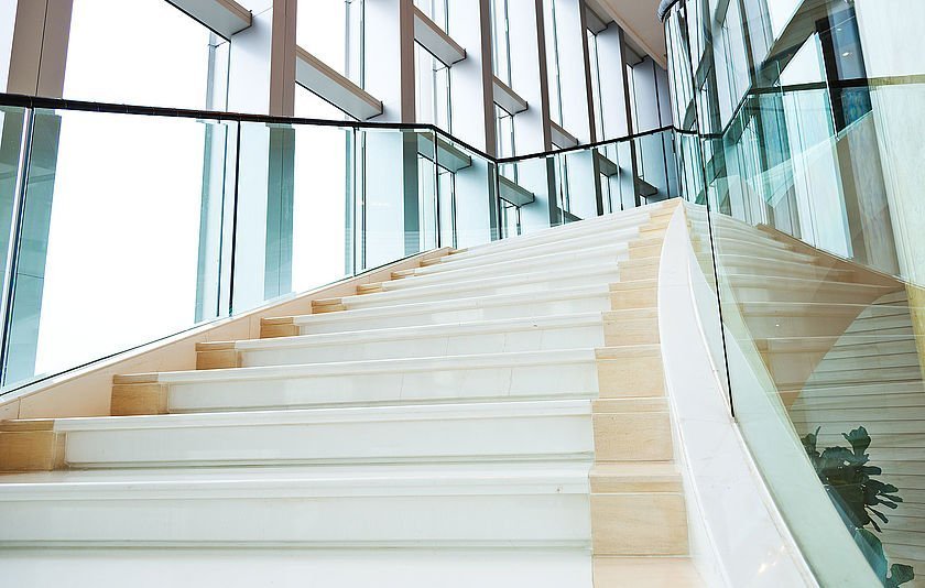 Weiße Treppe als Architektur-Element in licht-durchflutetem Aufgang.