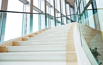 Weiße Treppe als Architektur-Element in licht-durchflutetem Aufgang.