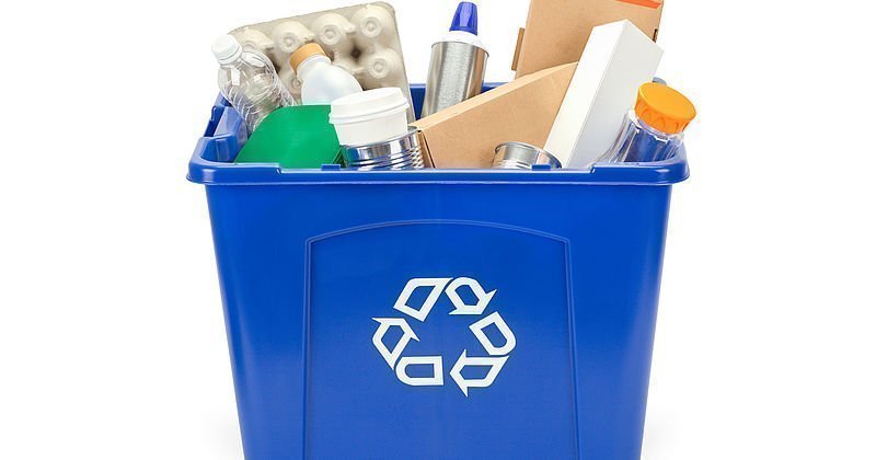 blaue Recyclingbox mit unterschiedlichen Materialien