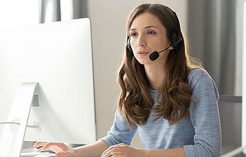 Frau mit Headset im Home Office