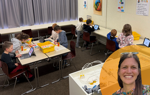 Das Bild zeigt das Klassengeschehen während der Robotik-Stunde der ersten Klasse. Die Grundschüler:innen arbeiten in Teams zusammen. Unten rechts im Bild ist das Porträt von Mathelehrerin Lisa Schwaab.
