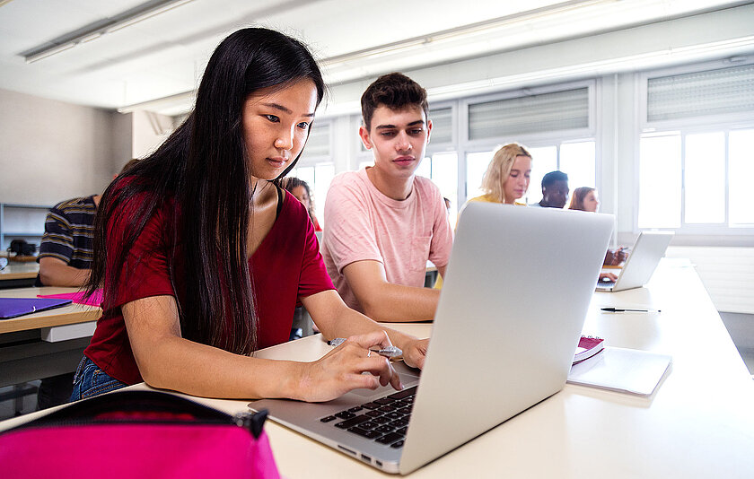 Asiatische Schülerin benutzt Laptop im Unterricht. Bildung. Zurück zur Schule.