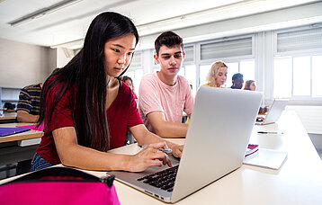 Asiatische Schülerin benutzt Laptop im Unterricht. Bildung. Zurück zur Schule.