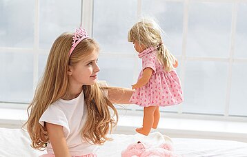 Spielendes Mädchen mit Puppe