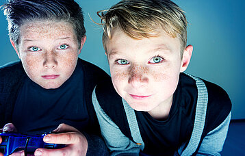 Zwei Jungs beim Computerspielen mit Playstation