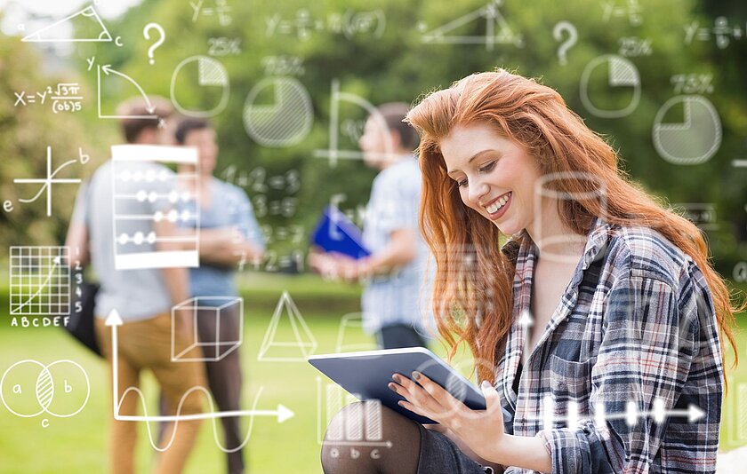 Junge Frau löst Mathematikaufgaben am Tablet Eine Jugendliche mit langen roten Haaren sitzt draußen im Grünen und schaut auf ein Tablet. Im Hintergrund sind Mengendiagramme, geometrische Körper und x-y-Diagramme zu sehen.