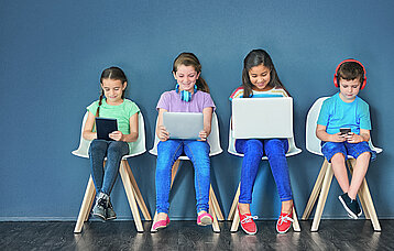Schulkinder mit mobilen Endgeräten