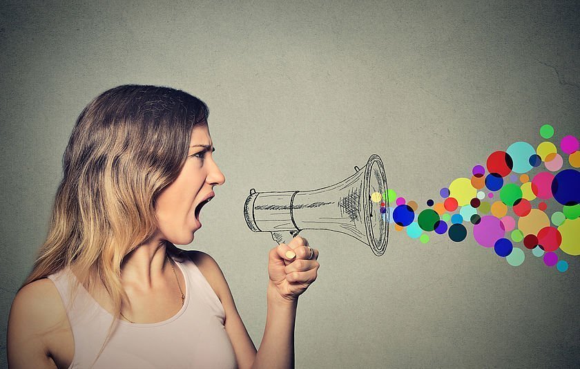 Frau ruft in ein gemaltes Megaphon, aus dem bunte Punkte kommen