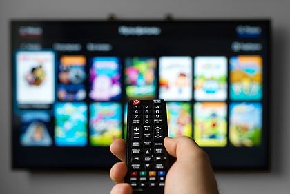 Hand hält Fernbedienung für SmartTV