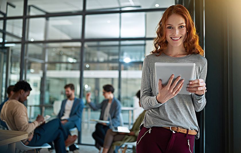 Junge Frau in einem Konferenzraum mit Tablet Junge Frau in einem Konferenzraum mit Tablet