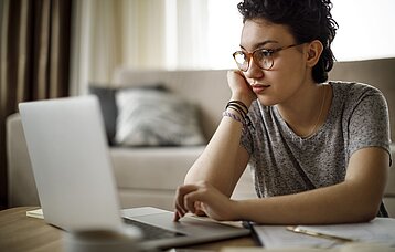 Junge Frau vor einem Laptop