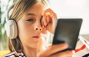 Mädchen mit Smartphone und Headset