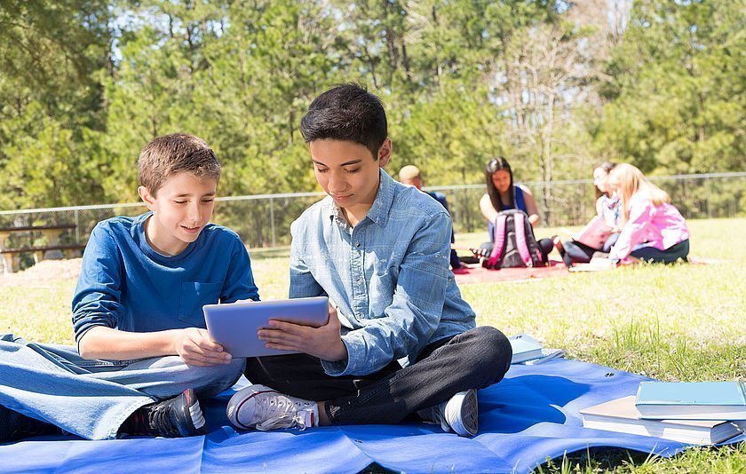 Zwei Jungs mit Tablet im Park