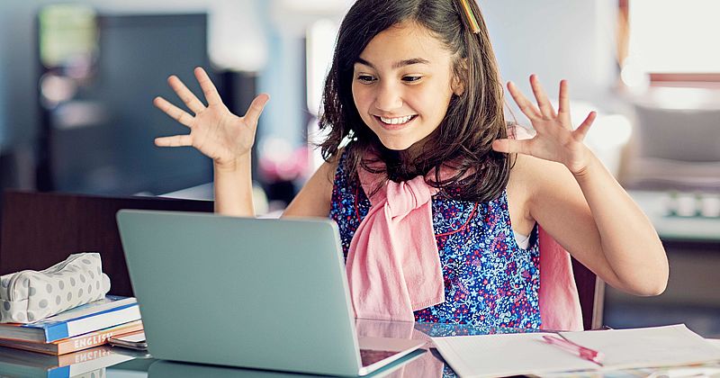 Lachendes Mädchen vor einem Laptop