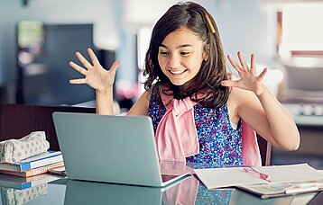 Lachendes Mädchen vor einem Laptop