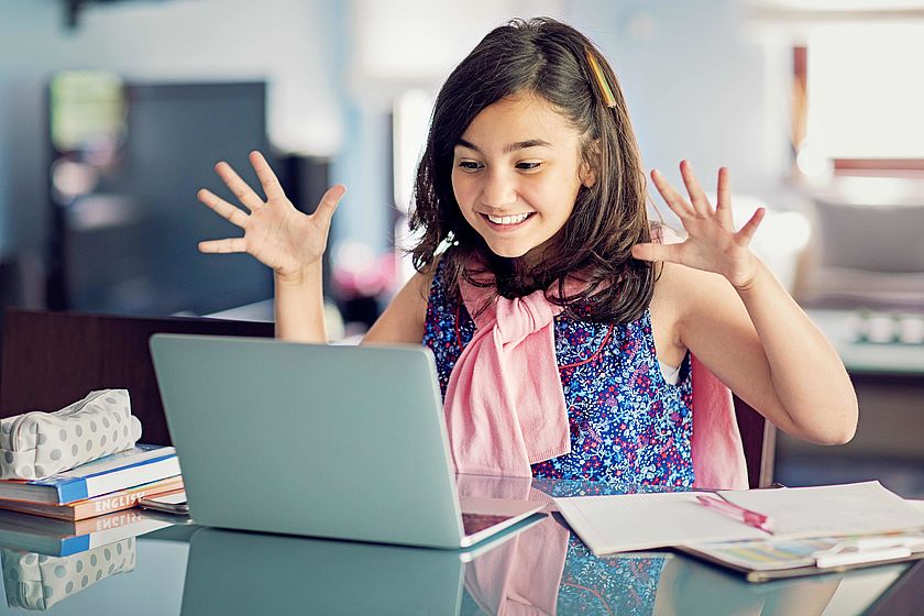 Lachendes Mädchen vor einem Laptop