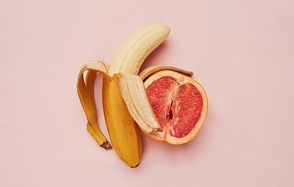 Halb geschälte Banane neben einer halben Grapefruit
