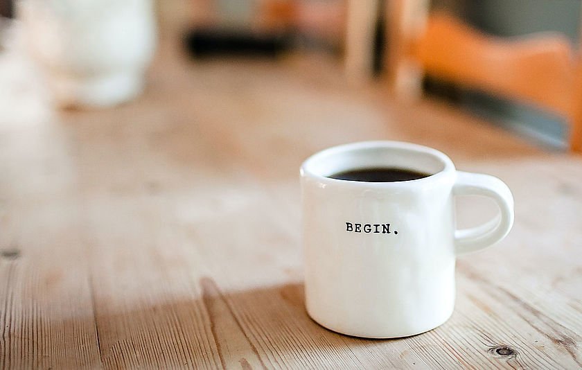 Kaffeetasse steht auf einem Holztisch