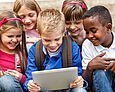 Fünf Grundschüler sehen auf ein Tablet