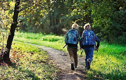 Zwei Kinder laufen im Wald
