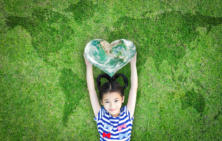 Mädchen mit Weltkarte in Herzform