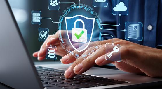 Man sieht einen aufgeklappten Laptop, darüber tippende Hände. Über dem Foto lagert eine Grafik mit einem Sicherheitsschloss, ein Symbol für eine Firewall.
