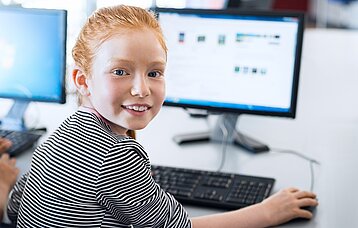 Schülerin vor einem PC-Bildschirm