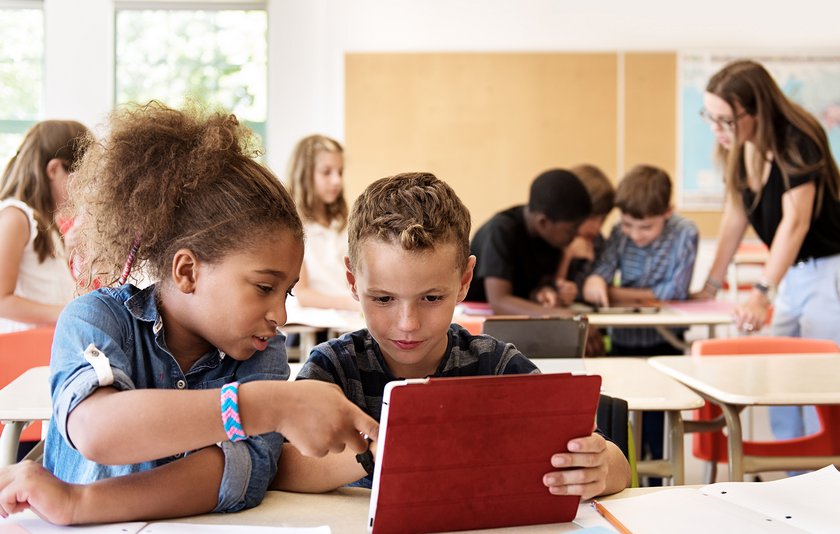 Zwei Schulkinder mit Tablet im Klassenzimmer